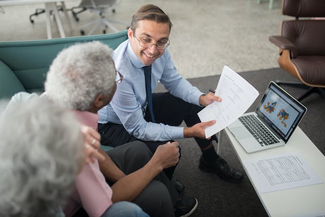 A realtor helping an elderly couple sell a home.