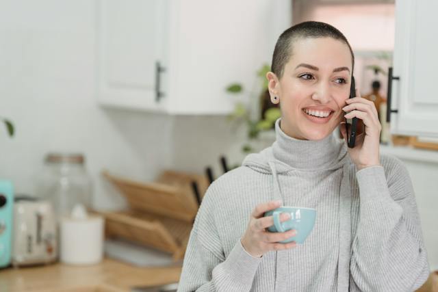 A lady smiling while on the phone.