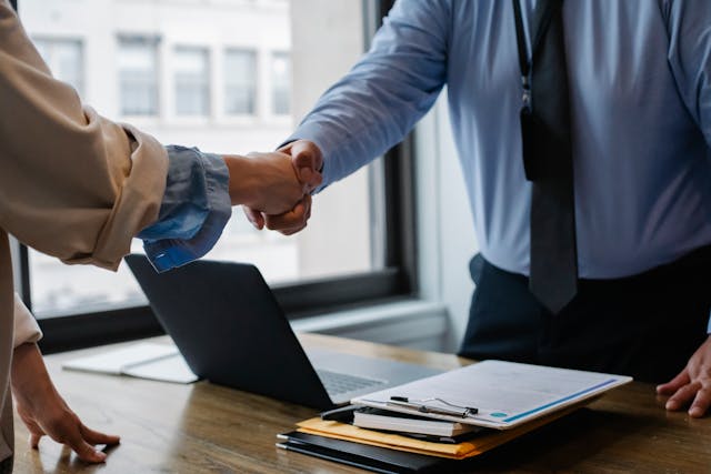 2 people shaking hands firmly.
