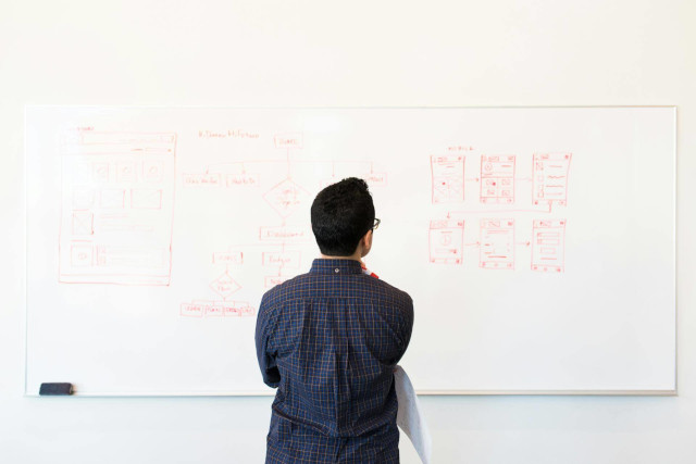 Man standing in front of a white board with a plan laid out.