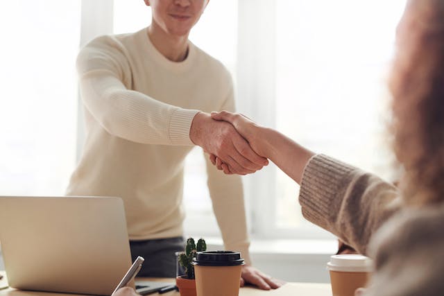 2 people shaking hands firmly.