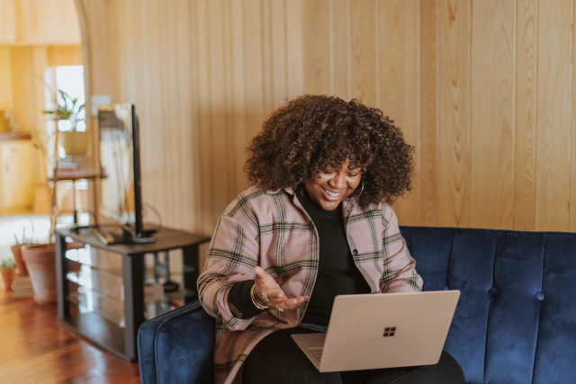 Woman Happily Communicating with Laptop