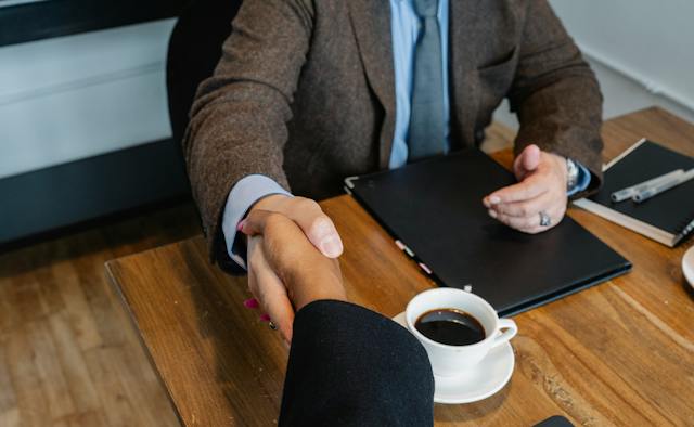 A firm handshake between 2 people.