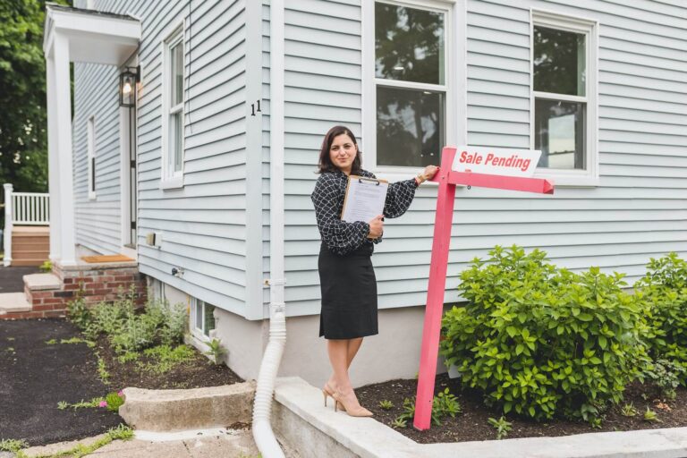 Realtor holding 'Sale Pending' sign.