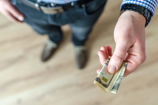 Man handing over cash to buy.